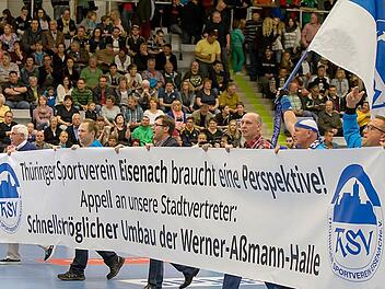 Verantwortliche und Fans des ThSV Eisenach appellierten bereits vor über einem Jahr mit einem großen Banner in der HUK-Arena an die Politik in Thüringen, endlich die für Erstliga-Handball zu kleine Werner-Aßmann-Halle zu vergrößern. Die Coburger Halle sei zwar "ein Traum", so ein ThSV-Fan, doch die Hoffnung "wieder zu Hause" zu spielen, sei groß. Jetzt steht fest, dass der Erstliga-Aufsteiger kein einziges Spiel in Eisenach durchführen darf. Als Ersatz-Spielort ist Coburg der große Favorit.  ...