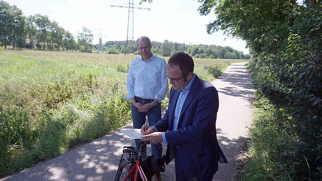 Florian Janik (vorne) und German Hacker unterzeichneten die Planungsvereinbarung auf dem Fahrradsattel.    Foto: Richard S&auml;nger
