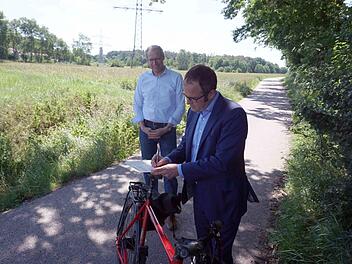 Florian Janik (vorne) und German Hacker unterzeichneten die Planungsvereinbarung auf dem Fahrradsattel.    Foto: Richard Sänger