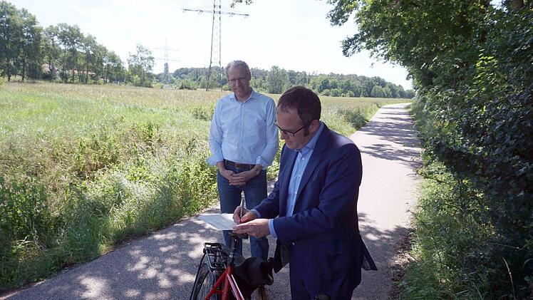 Florian Janik (vorne) und German Hacker unterzeichneten die Planungsvereinbarung auf dem Fahrradsattel.    Foto: Richard Sänger
