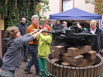 Handarbeit: Felix (links) und Noah setzen die Presse in Gang. Das erfordert viel Kraft.  Fotos: Gerd Schaar