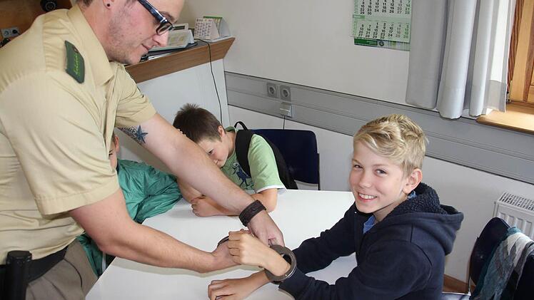 Gut Lachen hatte der neunjährige Christian, weil er wusste, dass die Handschellen wieder von PHM Schnaus gelöst werden.  Foto: Helmut Will