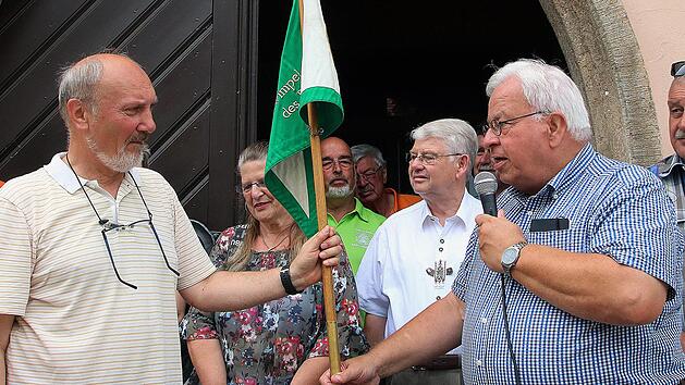 Nach Vacha muss der M&uuml;nnerst&auml;dter Rh&ouml;nklub-Zweigvereinsvorsitzende Egbert Haut (links) den Wimpel des Vorstandes im kommenden Jahr bringen. Rh&ouml;nklub-Pr&auml;sident J&uuml;rgen Reinhardt &uuml;berreichte das gute St&uuml;ck zur Aufbewahrung bis 2019. Die 75 Kilometer  lange Strecke muss zu Fu&szlig; zur&uuml;ckgelegt werden. Foto: Dieter Britz