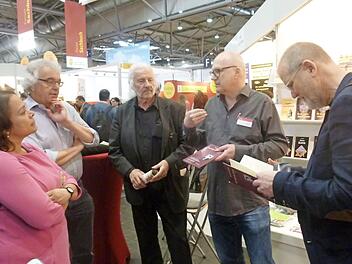 Verleger Rainer Breuer (Zweiter von rechts) und Ingo Cesaro (links daneben) sprechen auf der Buchmesse mit einer Gruppe Landtagsabgeordneter aus Rheinland-Pfalz über das Schicksal Jan Palachs. Ihm hat Cesaro einen Gedichtzyklus in dem Band "Dein Herz verbrannte nicht" gewidmet.  Foto: privat