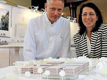 Ärztlicher Direktor Christoph Sommer und Katja Bittner, Vorstand des Kommunalunternehmens "Kliniken und Heime des Bezirks Oberfranken", hinter dem Sieger-Modell. Es besteht aus miteinander verbundenen, dreigeschossigen Baukörpern um einen attraktiven Gartenhof mit Blick ins Tal.