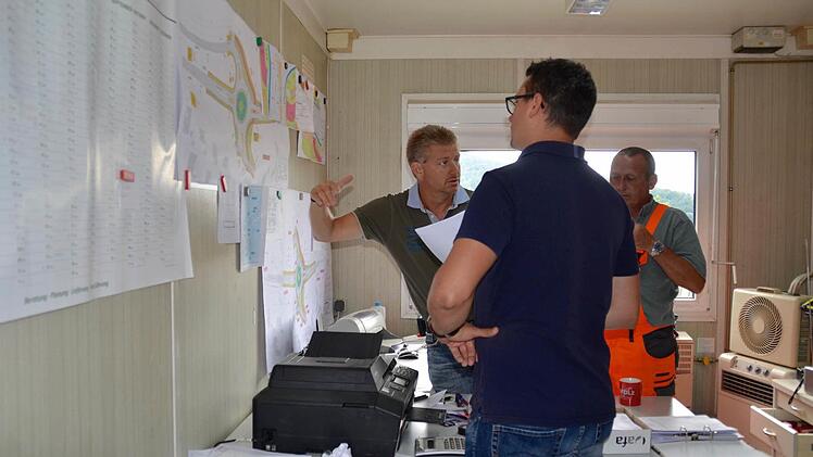Ein Blick in den Container, wo sich das Büro des Vorarbeiters befindet. Hier findet soeben die Baustellenbesprechung statt. Im Bild sind (von links) Steffen Kiesel, der Bauleiter vom Landratsamt, Patrick Könen, Kämmerer der Gemeinde Bad Bocklet, und Polier Robert Zeitz zu sehen. Foto: Kathrin Kupka-Hahn
