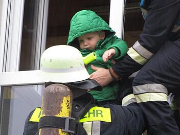 Auch der zweijährige Xaver wollte sich von den Feuerwehrmännern Manuel Statt (rechts) und Marc Farnberg "retten" lassen. Foto: Stephanie Elm