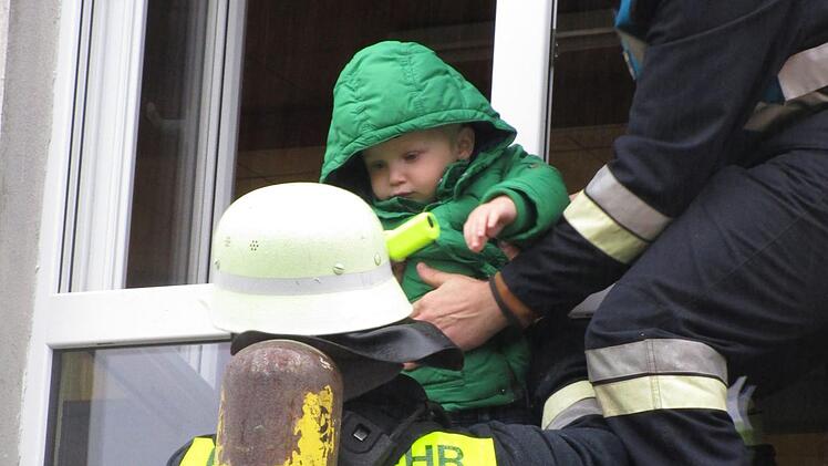 Auch der zweijährige Xaver wollte sich von den Feuerwehrmännern Manuel Statt (rechts) und Marc Farnberg "retten" lassen. Foto: Stephanie Elm