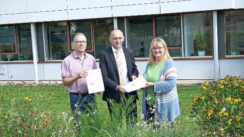 Christian Wosegien und Angelika Mechthold-Schmitz übergeben den Aktionsplan an Bürgermeister Heinrich Süß. Foto: Richard Sänger