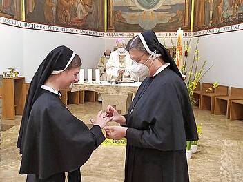 Schwester Veronika erhält von der Kongregationsleiterin Schwester Regina (rechts) den Ring mit dem franziskanischen Signet – ein Zeichen der nie endenden Treue Gottes.