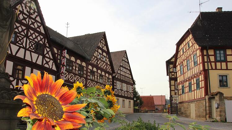 Fachwerkhäuser in Mürsbach mit farbenfrohen Sonnenblumen im Vordergrund, ein idyllisches Dorfambiente.