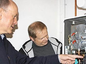 So groß wie ein Kühlschrank ist das Mini-Blockheizkraftwerk von Hans Dietrich Unger (links). Volker Wießner von den Bad Brückenauer Stadtwerken erläutert die Technik.  Foto: Archiv/ Ralf Ruppert