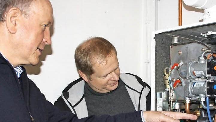 So groß wie ein Kühlschrank ist das Mini-Blockheizkraftwerk von Hans Dietrich Unger (links). Volker Wießner von den Bad Brückenauer Stadtwerken erläutert die Technik.  Foto: Archiv/ Ralf Ruppert