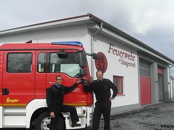 Der Kommandant der Stangenrother Freiwilligen Feuerwehr Sebastian Metz (links) und Vorsitzender Lorenz Höchemer freuen sich. Das Feuerwehrauto der engagierten Floriansjünger ist nagelneu, ebenso wie das Feuerwehrgerätehaus. Foto: Joachim Rübel