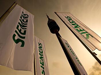 Fahnen mit dem Schriftzug der Siemens AG in München. Foto: Sven Hoppe/dpa