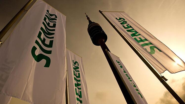 Fahnen mit dem Schriftzug der Siemens AG in München. Foto: Sven Hoppe/dpa