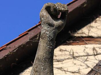 Der rechte, erhobene, Arm der Figur weist mit die stärksten Schäden auf. So sieht er mittlerweile, dank Absplitterungen und Flechten-Bewuchs, fast schon wie ein verrottender Ast aus. Foto: Katharina Brecht