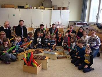Sie freuen sich mit den Kindern des Schulprojektes (hinten, von links): Schondras 2. Bürgermeisterin Beatrix Lieb, Schulleiter Otto Granich, Pascal Reh (Vorsitzender Musikkapelle Schönderling), Gerodas Bürgermeister Alexander Schneider, Arnold Scheller (Musikverein Schondra), Achim Scholz (Jugendblasorchester Scholz, Geroda), stellvertretende Schulleiterin Sabine Kreil, Klassenlehrerin Caroline Karner, Yvonne Roth-Wächter (August-Kömpel-Musikschule). Foto: Beatrix Lieb