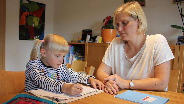 Für ihren ersten Schultag ist Mara perfekt vorbereitet. Gemeinsam mit Mama Steffi Rüger übt sie ihren eigenen Namen zu schreiben. Foto: Lisa Kieslinger
