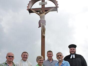 Die Pfarrer Norbert Lang (Zweiter von links) und Tobias Knötig (rechts) segneten das neue Wegekreuz bei Gleismuthhausen. Jutta und Daniel Angermüller (Mitte) hatten die Initiative ergriffen, das christliche Symbol neu zu gestalten. Auch Ludwig Rößner (links) und Bruno Tranziska hatten kräftig mitgewirkt.  Foto: Carsten Höllein