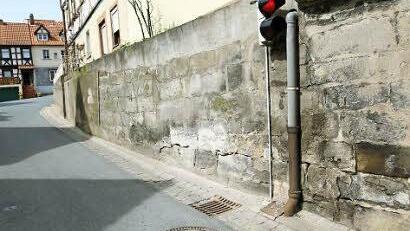 Die Straße geht direkt bis an die Mauer. Feuchteschäden sind die Folge.