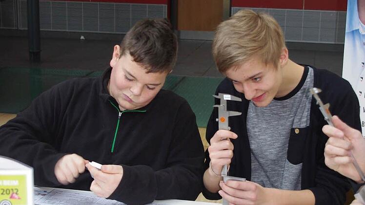 Nico Remmert-Hartan und Alexander Ketterer (von links) messen mit dem Messschieber.