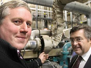 Landwirt Albert Sebald und sein zweiter Geschäftsführer Franz Rößner zeigen einen Motor im BHKW.