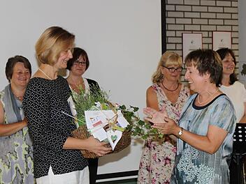 Christine Weininger überreicht Sigrid Schumm (r.) einen Präsentkorb. Dahinter stehen die Kolleginnen vom Lehrerchor. Foto: Carmen Schwind