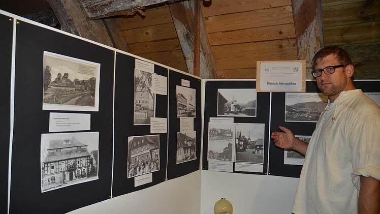 Michael Bohl führt durch die historische Bilderausstellung die Gebäude und Ansichten von Gebäuden und Plätzen von Weißenbrunn, die es so heute nicht mehr gibt. Foto: K.- H. Hofmann