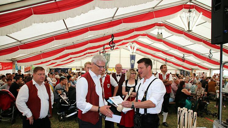 Zum Schluss des Kreismusikfestes überreichte Andreas Böhm, Vorsitzender der Blaskapelle Neundorf (rechts), an Vertreter jeder teilnehmende Kapelle ein Exemplar des extra vom Neundorfer Dirigenten und Komponisten Sascha Dalke komponierten Marsches, hier an Konrad Keller (Autenhaus'ner Musikanten). Foto: Bettina Knauth