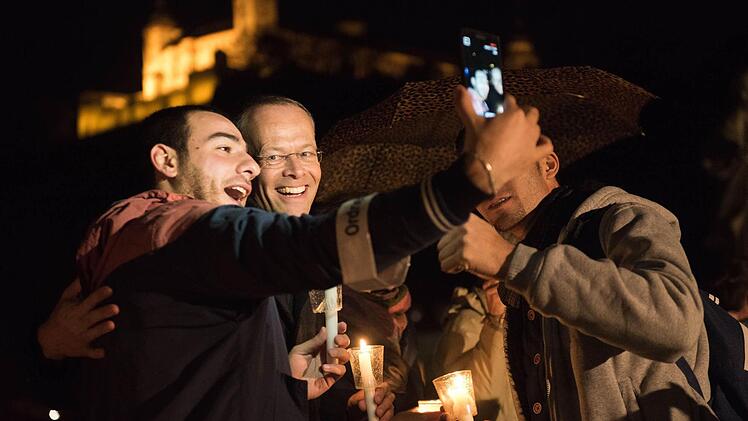 Ein paar hundert Menschen demonstrieren vor einem Jahr mit einer Lichterkette auf der Alten Mainbrücke und am Mainkai gegen Rassismus und Fremdenhass. Mit dabei war auch Burkhard Hose. Foto: Daniel Peter