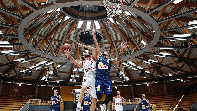 Michele Vitali zieht in der Arena Hohenlohe, einer Rundsporthalle, gegen den ehemaligen Bamberger Maurice Stuckey (r.) zum Korb.  Foto: Daniel L&ouml;b