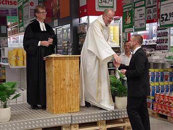 Pfarrer Martin Gundermann und Domkapitular Thomas Teuchgr&auml;ber (von links) &uuml;bergaben  ein Kreuz an den Hagebau-Gesch&auml;ftsf&uuml;hrer Eric Bienlein-Karst. Foto: Heike Sch&uuml;lein