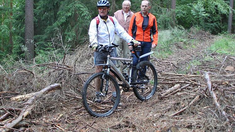 Ein Jahr danach: Die breiten Rückegassen, die der Staatsforst im Bereich Kessel/Rehberg angelegt hat, sind fast unpassierbar. Es ist zwar Gras auf den Wegen gewachsen, aber der Ärger der Spaziergänger, Jogger und Mountainbiker ist geblieben. Das Gestrüpp und Kleinholz, das die Forstleute zum Schutz des Bodens bewusst liegenlassen, regt Reiner Racek, Jobst Rathmann und Thomas Strunz (von links) auf. Fotos: Stephan Tiroch