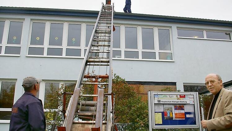 Aktuell steigen die Arbeiter der Schule aufs Dach. Schulleiter Friedrich Tasch (rechts) nimmt es gelassen. Fotos: Tom Müller