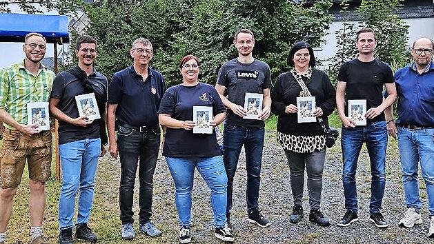 Pfarrgemeinderatsvorsitzender Markus Montag (links) und Kirchenpfleger Bernd Peter (rechts) &uuml;berreichten Spenden an Mitwirkende des Weihnachtsmarkts.