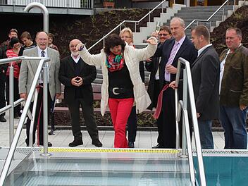 Bürgermeister-Gattin Maria Brehm (Mitte) durfte am Mittwochabend das Band am erneuerten 50-Meter-Becken des Höchstadter Wellenfreibads durchschneiden. Foto: Andreas Dorsch