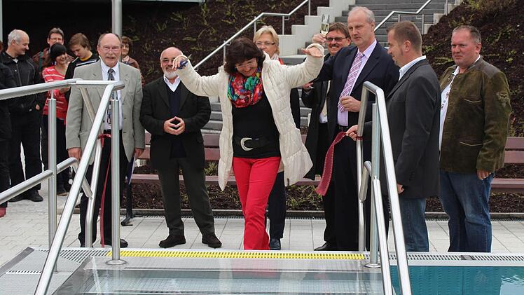 Bürgermeister-Gattin Maria Brehm (Mitte) durfte am Mittwochabend das Band am erneuerten 50-Meter-Becken des Höchstadter Wellenfreibads durchschneiden. Foto: Andreas Dorsch