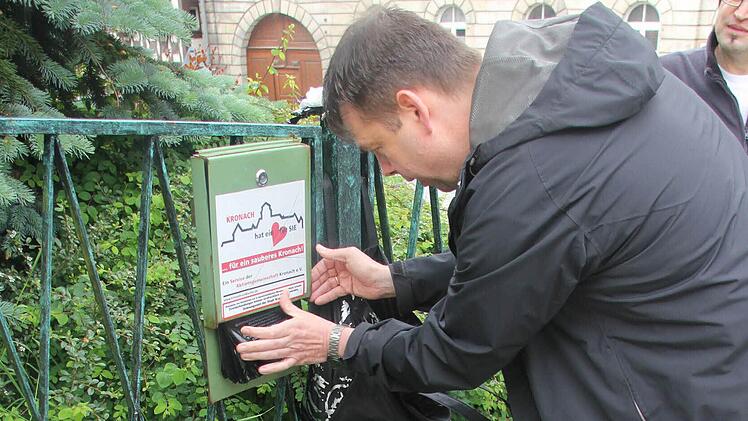 Johannes Fehn bringt den Aufkleber auf der Station in der Rosenbergstraße an. Fotos: Corinna Igler