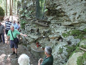 Schaden die Kerzenhalter diesem Felsen der Mariengrotte? Heinz Fausten (deutend) hat da eine ander Ansicht als Förster Wolfgang Gnannt (vorne rechts). Fotos Ralf Kestel