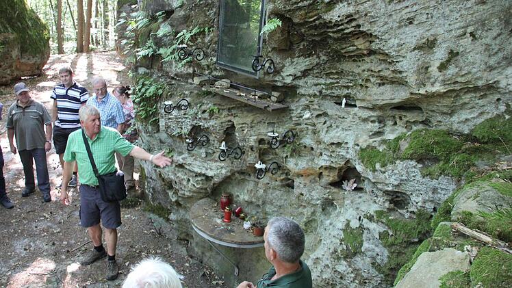 Schaden die Kerzenhalter diesem Felsen der Mariengrotte? Heinz Fausten (deutend) hat da eine ander Ansicht als Förster Wolfgang Gnannt (vorne rechts). Fotos Ralf Kestel