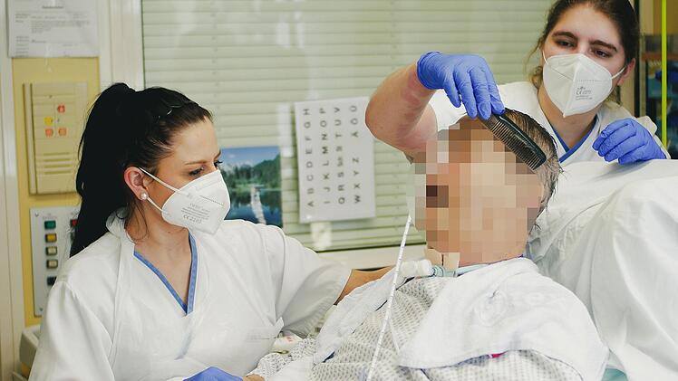 Schwester Claudia (links) und Schwesternsch&uuml;lerin Michelle waschen einem Patienten auf der Intensivstation die Haare.