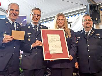 Die FFW Forchheim &uuml;bergab eine Reproduktion einer historischen Dienstbescheinigung (v.&nbsp;l.): Reinhold Zametzer (stellvertretender Vorsitzender Feuerwehr Kersbach), Josua Flierl (Vorsitzender Feuerwehr Forchheim), Carina Fees (Vorsitzende Feuerwehr ...