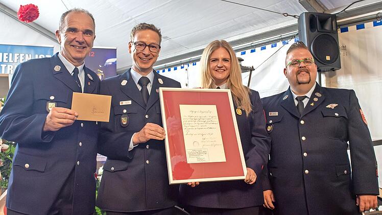 Die FFW Forchheim &uuml;bergab eine Reproduktion einer historischen Dienstbescheinigung (v.&nbsp;l.): Reinhold Zametzer (stellvertretender Vorsitzender Feuerwehr Kersbach), Josua Flierl (Vorsitzender Feuerwehr Forchheim), Carina Fees (Vorsitzende Feuerwehr ...
