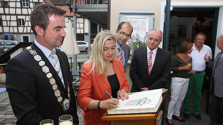 Staatssekretärin Melanie Huml trägt sich ins Goldene Buch ein.