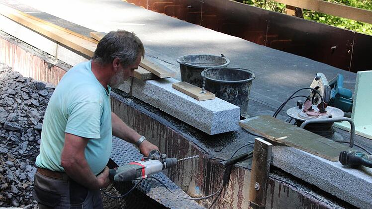 Ein Arbeiter bohrt die Befestigung für die Schalung.  Foto: Friedwald Schedel