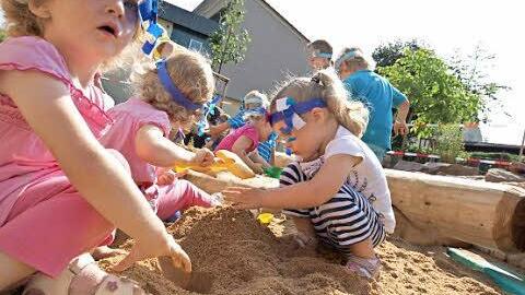 Kinder spielen im Sandkasten.