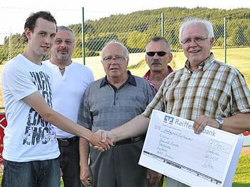 TSV-Vorsitzender Leonhard Welscher (rechts) überreicht den symbolischen Scheck über 1500 Euro an Daniel Zwosta. Mit im Bild dessen Vater Manfred Zwosta, Großvater Georg Wachter und Spielgruppenleiter Egon Grünbeck (von links). Foto: Herbert Kalb