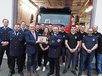 Bürgermeister Harald Hübner (Vierter von links) übergibt dem Kommandanten der Feuerwehr, Markus Schirmer, (Neunter von links) eines der 42 Funkgeräte. Die Feuerwehr Neudrossenfeld ist Teil eines Pilotprojektes im Leitstellenbereich Bayreuth, das d...