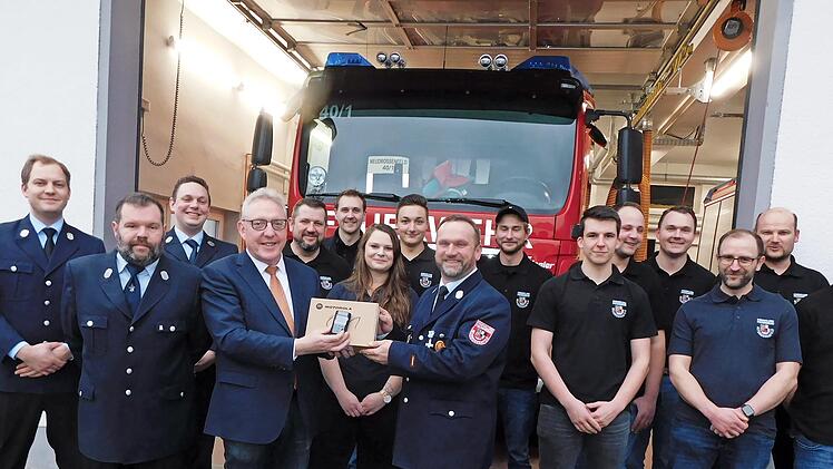 Bürgermeister Harald Hübner (Vierter von links) übergibt dem Kommandanten der Feuerwehr, Markus Schirmer, (Neunter von links) eines der 42 Funkgeräte. Die Feuerwehr Neudrossenfeld ist Teil eines Pilotprojektes im Leitstellenbereich Bayreuth, das d...